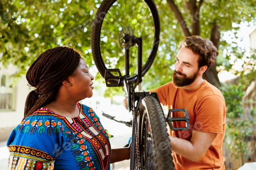 Preview: Sportloving couple inspecting bicycle