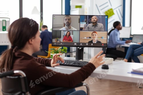 Preview: Paralyzed businesswoman in wheelchair having online videocall meeting conference
