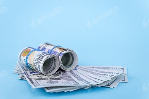 Preview: Rolled One Hundred Dollar Bills on Blue Background