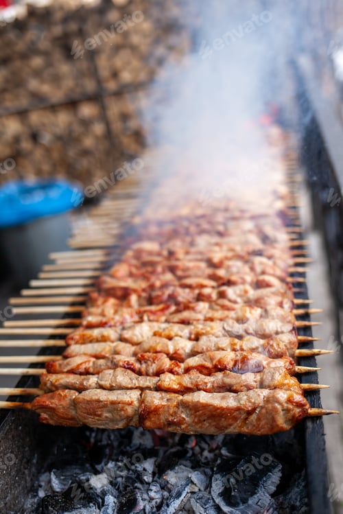Preview: A lot of juicy meat kebabs in a row on the grill.