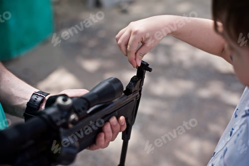 Preview: A young father teaches his son how to shoot an air rifle