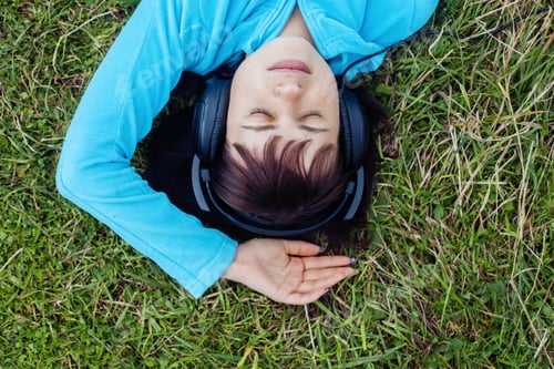 Preview: young girl listening to music on headphones. top view. The concept of lifestyle.