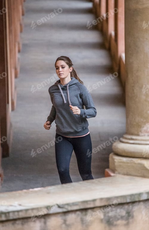 Preview: Young woman wearing sports clothes jogging