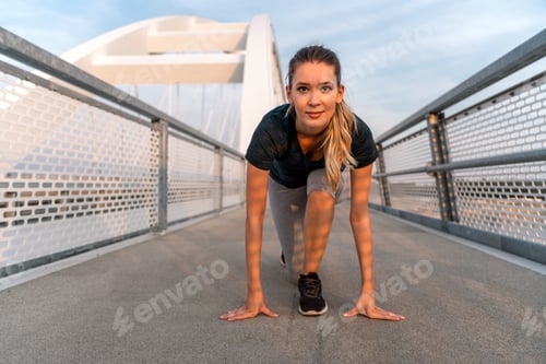 Preview: Young sport woman stretching and preparing to run outdoors in city