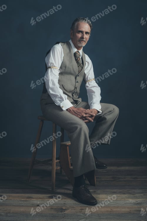 Preview: Confident Retro 1920S Fashion Man Sitting On Wooden Chair In Empty Room.