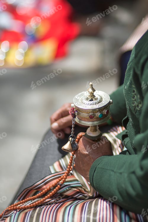 Preview: Old woman praying with prayer roll in Lhasa