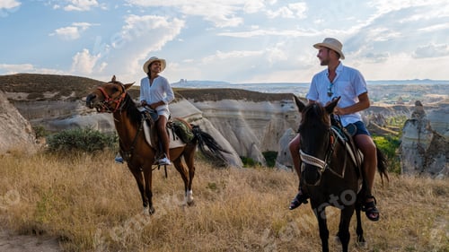 Preview: happy young couple on vacation Turkey Kapadokya horse riding in the mountains of Cappadocia Goreme