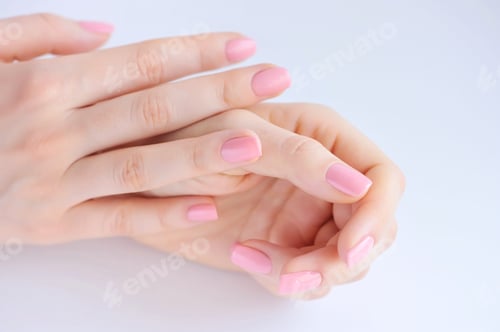 Preview: Closeup of hands of a young woman with pink manicure on nails ag