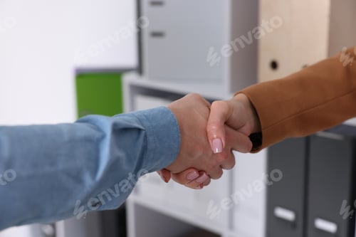 Preview: Business partners shaking hands in office, closeup