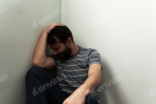 Preview: Grieving man in his 30s sitting alone on the floor