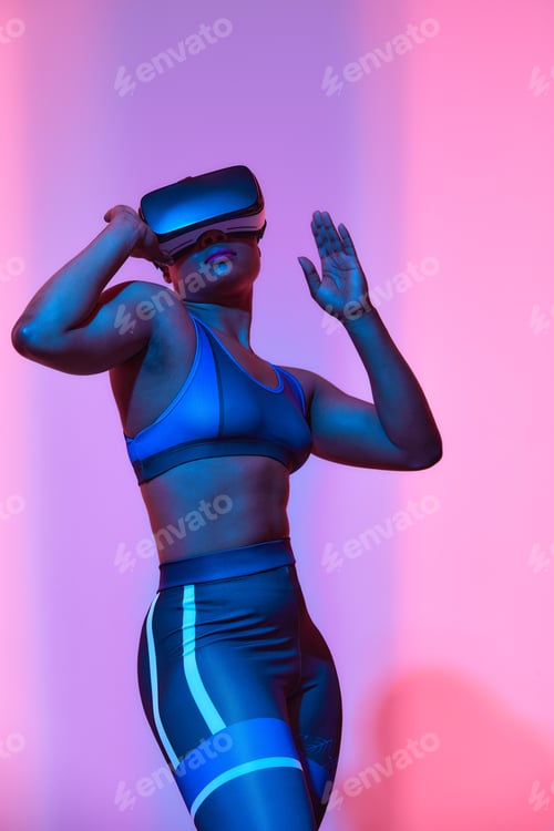 Preview: Modern african black woman with short hiar in sport top and leggings wearing glasses of virtual