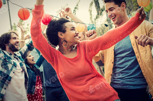 Preview: A group of men and women at a party dancing outdoors.