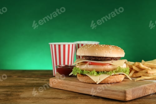 Preview: Delicious fast food menu on wooden table against green background. Space for text