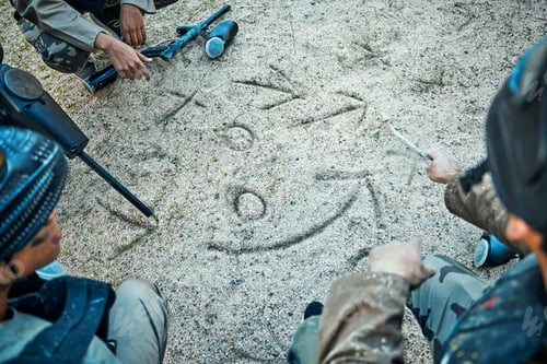 Preview: Paintball, battlefield and team with game plan, mission and strategy drawing in sand with soldier g