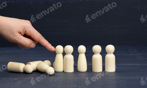 Preview: Hand pushes the wooden figures of men, they fall in different directions.
