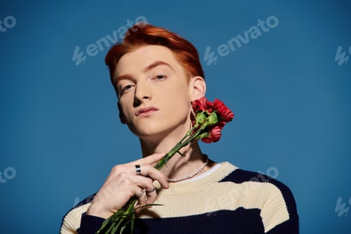 Preview: Emotional young man with flowers against a blue background expressing deep feelings