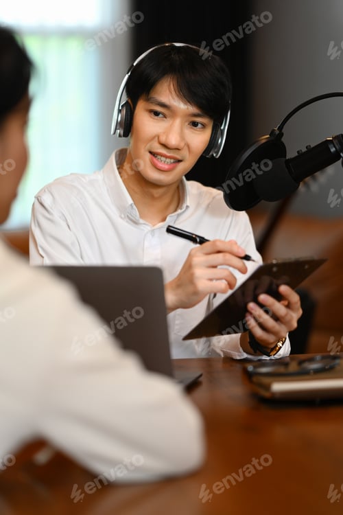 Preview: Male radio host discussing various topics with her guest while streaming live audio podcast.