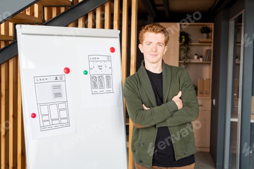 Preview: Young successful coach or mobile app developer crossing his arms by chest