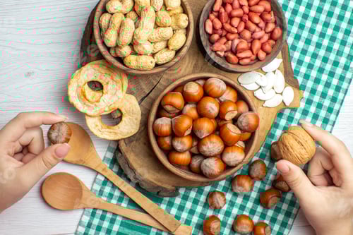 Visualização: vista superior: avelãs cruas frescas com amendoim em fundo branco, lanche, nozes, alimentos vegetais, filme, nogueira