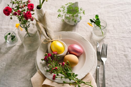 Preview: Happy Easter. Stylish easter eggs on a napkin with spring flowers on white wooden background