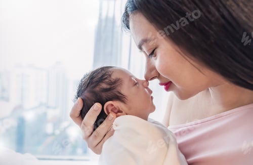 Preview: Closeup portrait of beautiful young asian mother kissing nose to nose with newborn baby