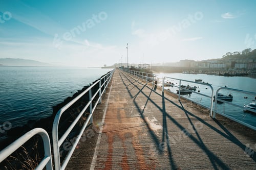 Preview: wide angle shot of pier and port next to the sea and the bicycle lane of town during cloudy