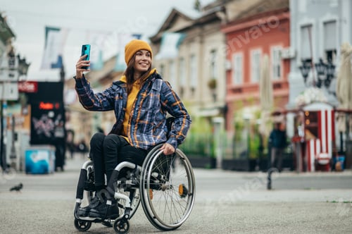 Preview: Woman with disability taking a selfie with her smartphone while out in the city