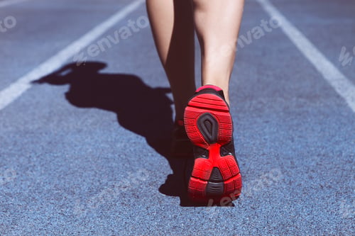 Preview: Athlete runner feet down stadium track. Closeup on female shoe and legs. Woman fitness workout