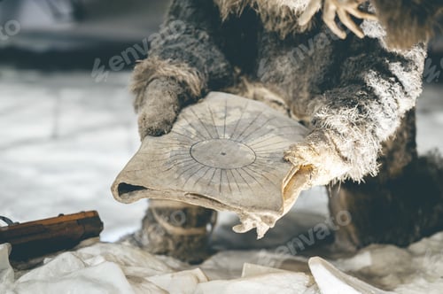 Preview: Closeup shot of a man with warm clothes keeping a paper with a symbol in a cold snowy place