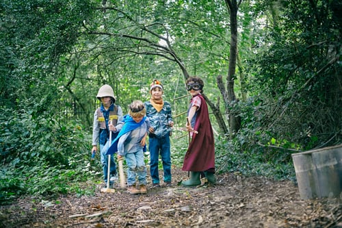 Preview: Four boys dressed up and playing in forest
