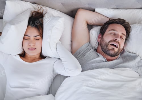 Preview: Make it stop. Shot of a young woman struggling to sleep with her boyfriends snoring at home.
