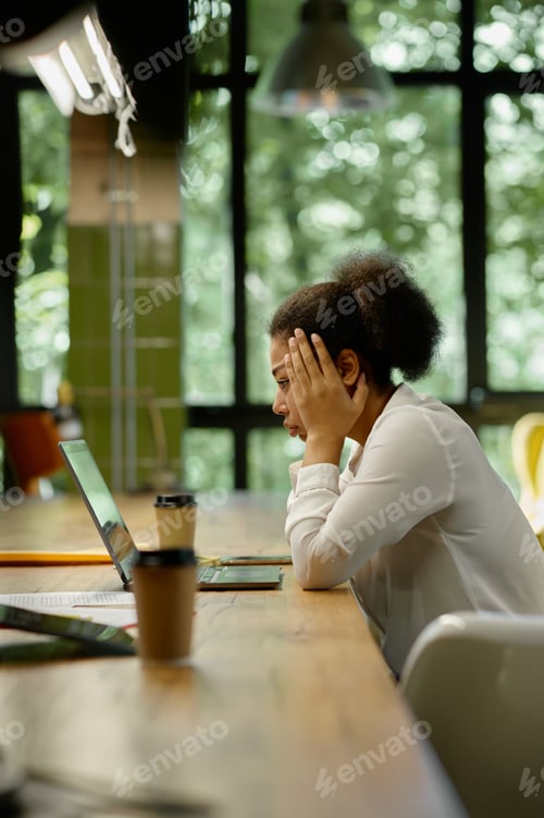 Preview: Shocked worried business woman looking at laptop sitting in office