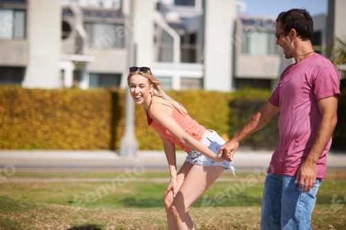 Preview: Couple fooling around outdoors, holding hands, laughing