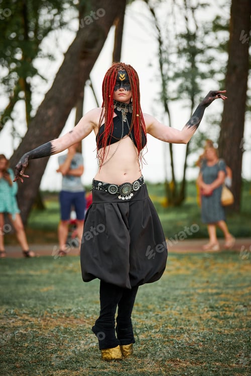 Preview: Mythological dancing girl faun on green lawn in public park outdoor art dancing event