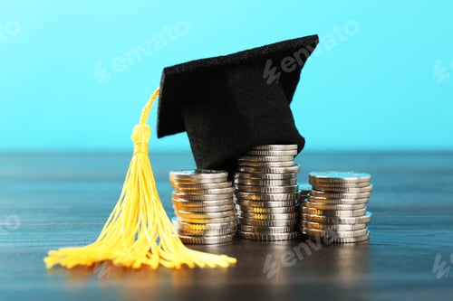 Preview: Scholarship. Graduate hat and coins on wooden table against light blue background, closeup