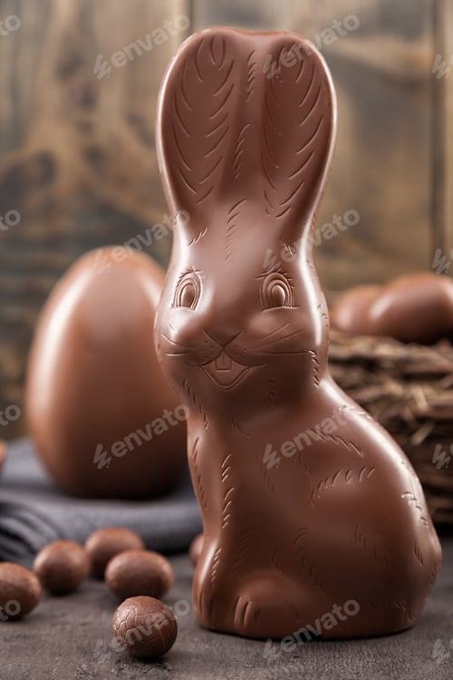 Preview: Chocolate Easter bunny, eggs and sweets on rustic background
