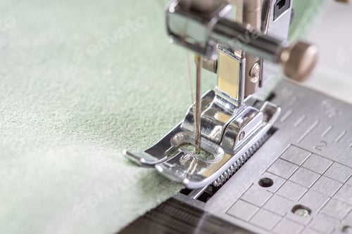 Preview: Modern Sewing Machine Presser Foot With Green Fabric And Thread, Closeup, Macro