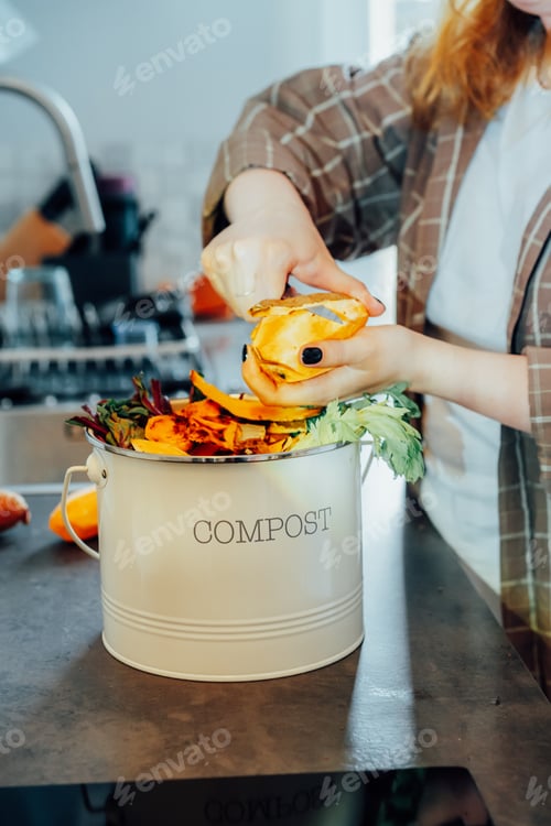 Preview: Compost the kitchen waste, recycling at home. Woman putting cutted leftovers into compost bin