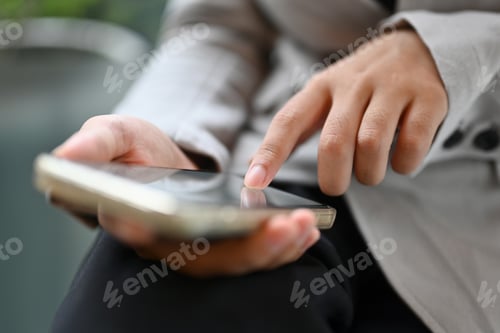 Preview: Closeup of young woman typing on mobile phone reading text or chatting online
