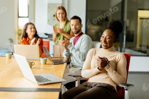 Preview: Cute Africam American woman with her young multiethnic startup team working in the modern office