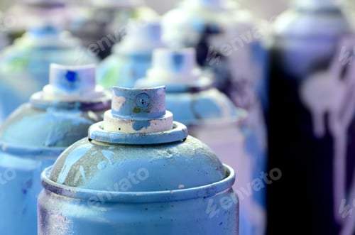 Preview: A lot of dirty and used aerosol cans of bright blue paint
