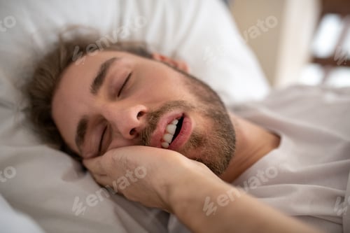 Preview: Young man sleeping in his bed in the morning