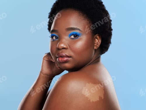 Preview: Studio shot of a beautiful young woman posing against a blue background