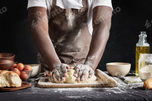Preview: Cropped shot of talented dark skinned male cook kneads studiously dough, prepares for culinary compe