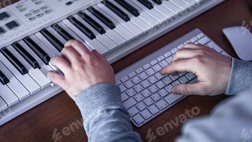 Preview: Male musician creates music using computer and keyboard, musician workplace.