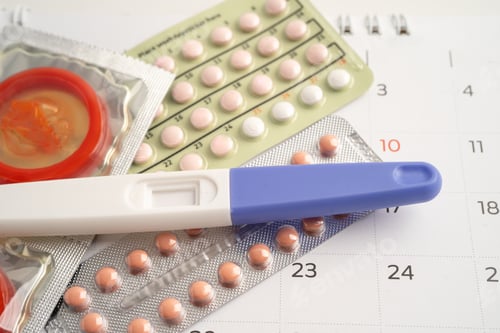 Preview: Pregnancy test and birth control pills on calendar, contraception health and medicine.