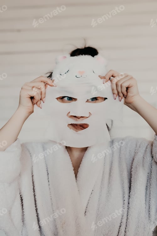 Preview: Girl in a white bathrobe takes care of herself and uses a cosmetic mask