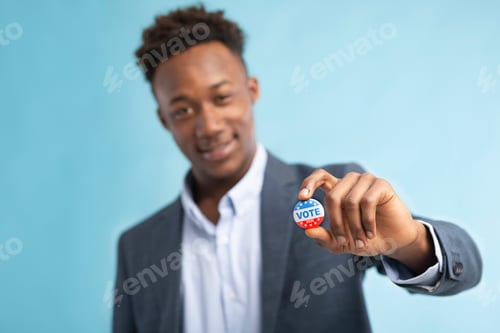 Preview: African american man showing vote pin, blurred background