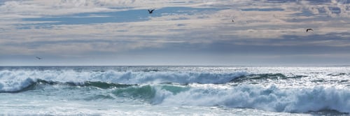 Ocean Waves Crashing Under a Cloudy Sky