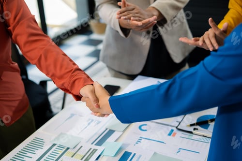 Preview: businesspeople putting hands together above the table express unity and support.